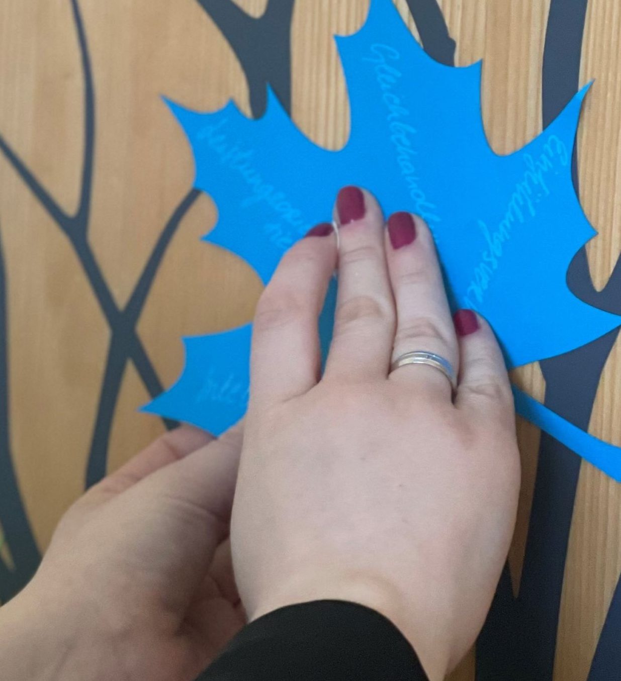 Mitarbeitende befestigt ein Blatt mit ihren individuellen Stärken am Stärkenbaum