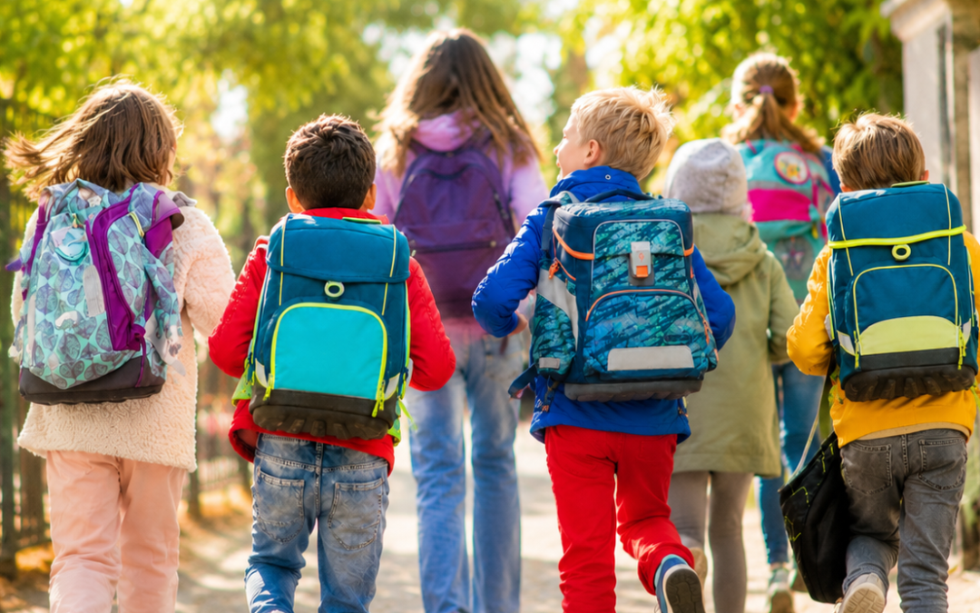 Laufende fröhliche Schulkinder von hinten